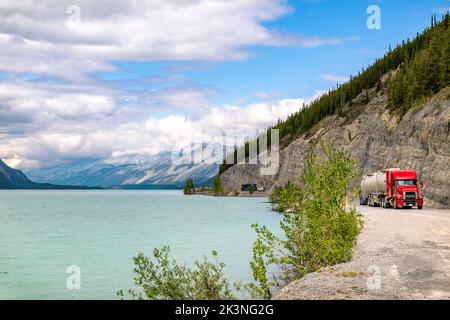 Traktoranhänger fährt auf dem Alaska Highway entlang des Muncho Lake, umgeben von den kanadischen Rocky Mountains, British Columbia und Kanada Stockfoto