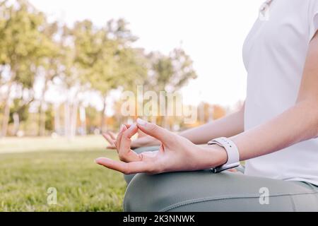 Nahaufnahme einer Frau in der Lotushaltung. Yoga im Freien, Achtsamkeit, gesunder Lebensstil Stockfoto
