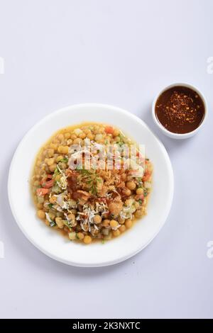 Mein Lieblings-Chotpoti im Rahmen, pikante Chana Chat Masala Chotpoti in einem schwarzen Gericht, isoliert im Hintergrund mit Blick von oben auf indisches, bangali und pakistanisches Essen Stockfoto