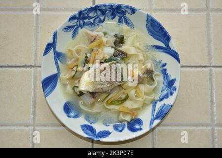 Nahaufnahme einer Schüssel mit gelben croaker Nudeln in frischer Suppe Stockfoto
