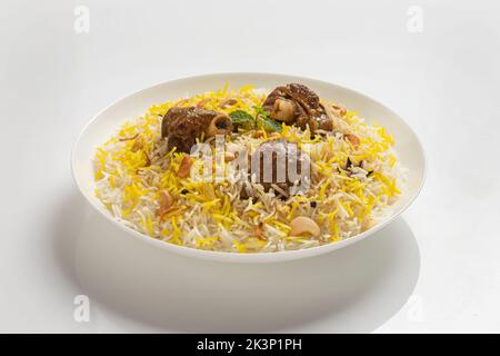 Dhum biriyani mit Jeera-Reis und Gewürzen in Erdenware mit Salat auf weißem Hintergrund. Stockfoto