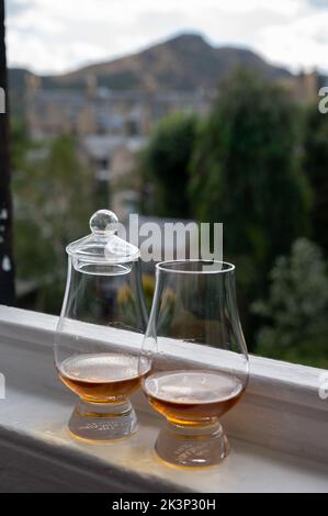 Zwei Gläser Single Malt Scotch Whisky, serviert auf einer alten Fensterbank im Scottisch House, mit Blick auf den alten Teil von Edinburgh, Schottland, Großbritannien, mit einem Schluck Whisky Stockfoto