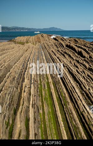 Blick auf steil geneigte Schichten von Flysch-geologischer Formation an der Atlantikküste bei Zumaia bei Ebbe, Baskenland, Spanien Stockfoto