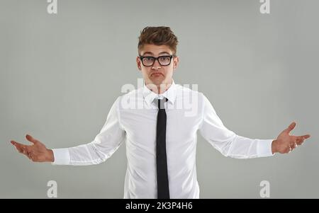 Was sehen Sie sich an? Ein junger Mann mit Brille, der vor der Kamera gestikuliert. Stockfoto