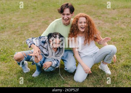 Fröhliche Gruppe von Freunden, die Spaß haben und gemeinsam Zeit auf der College-Pause im University Park verbringen. Freundschaftskonzept mit tausendjähriger Generation. Tag von Stockfoto