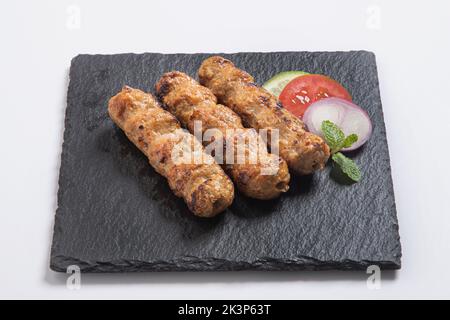 Seekh Kabab aus gehacktem Huhn oder Hammelkiema, serviert mit grünem Chutney und Salat Stockfoto