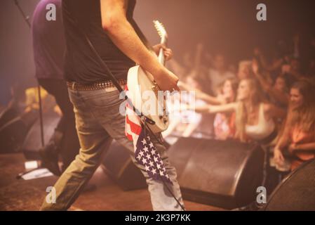 Super krank solo. Ein Gitarrist, der ein krankes Solo aufführt, während er mit seiner Band bei einem vollgepackten Gig rockt. Stockfoto