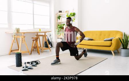 Junger afrikanischer Mann, der zu Hause Fitness trainiert Stockfoto
