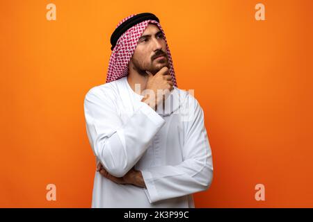 Junger arabischer Mann in traditioneller Kleidung, der an etwas denkt Stockfoto
