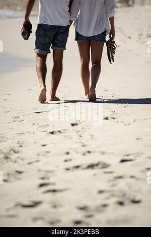 Strandspaziergang. Zugeschnittenes Bild eines Paares, das am Strand läuft. Stockfoto