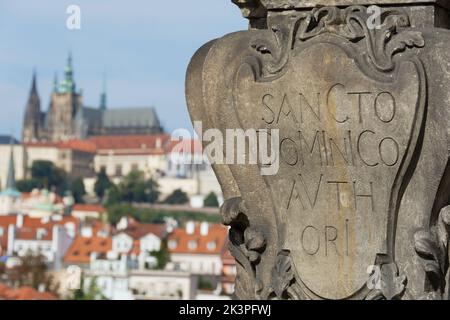 Inschrift: Sancto dominico avth ori auf der Prager Karlsbrücke und im Hintergrund die Prager Burg Stockfoto