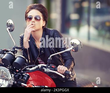 Eine junge Biker raucht eine Zigarette. Stockfoto