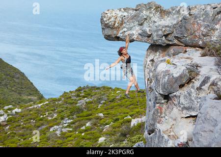 Ich gehe auf alle Längen für die perfekte Aussicht. Eine schöne junge Frau beschäftigt Rock Klettern die Seite eines Berges. Stockfoto