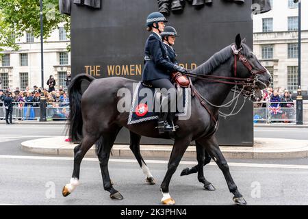 Berittene weibliche Polizeibeamte passieren das Women of World war Two Monument in Whitehall, London, Großbritannien. Stockfoto