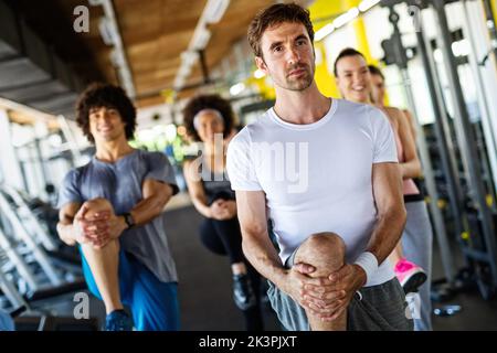 Multiethnische Gruppe von Menschen, die in einem Fitnessstudio trainieren. Trainer und sportlich fit trainierende Personen Stockfoto