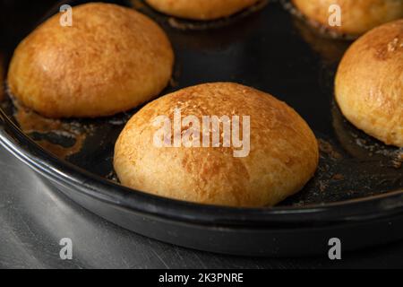 Frisch gebackene heiße Burger-Brötchen in einem Industrieofen Stockfoto