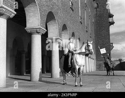 In der 1940s. Der amerikanische Film Jeanne d'Arc wird zur Premiere befördert und Kerstin Bergo wurde als Ingrid Bergman im PR-Stunt ausgewählt. Sie sah beide ein wenig wie Ingrid Bergman aus und konnte reiten. Im Hintergrund das Rathaus von Stockholm. Stockholm Schweden 1949. Kristoffersson Ref. AO18-1 Stockfoto