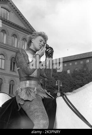 In der 1940s. Der amerikanische Film Jeanne d'Arc wird zur Premiere befördert und Kerstin Bergo wurde als Ingrid Bergman im PR-Stunt ausgewählt. Sie sah beide ein wenig wie Ingrid Bergman aus und konnte reiten. Sie schafft es, ihr Make-up sogar als Ritter in Rüstung gekleidet zu verbessern, indem sie einen Taschenspiegel in ihrer metallbedeckten Hand und den Lippenstift in der anderen hält. Stockholm Schweden 1949. Kristoffersson Ref. AO17-2 Stockfoto