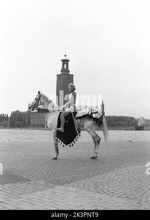 In der 1940s. Der amerikanische Film Jeanne d'Arc wird zur Premiere befördert und Kerstin Bergo wurde als Ingrid Bergman im PR-Stunt ausgewählt. Sie sah beide ein wenig wie Ingrid Bergman aus und konnte reiten. Im Hintergrund das Rathaus von Stockholm. Stockholm Schweden 1949. Kristoffersson Ref. AO17-6 Stockfoto