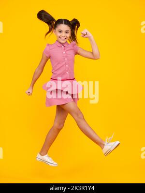 Glücklicher Teenager, positive und lächelnde Emotionen des Teenagers. In voller Größe Foto von positiven Teenager-Mädchen springen mit Bewegung Sommerkleid, Mode Kinder Outfit Stockfoto