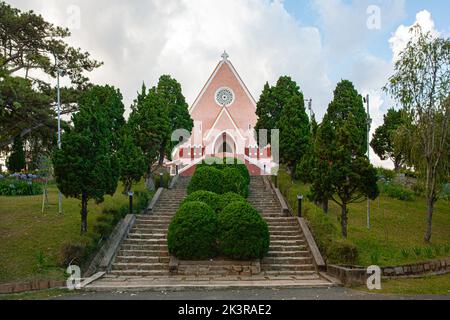 Mai Anh Domaine De Marie Kirche Diözese auf blauem Himmel Hintergrund, versteckt hinter Kiefern am sonnigen Tag mit Vorderansicht, in Da Lat, Lam Dong prov Stockfoto