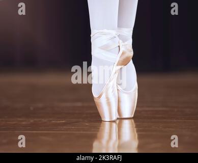 Ballett, Tanz und Schuhe mit den Füßen einer Ballerina oder Tänzerin, die auf einer Theaterbühne für eine Aufführung oder Show tanzt. Kreativ, Kunst und Ausbildung mit Stockfoto