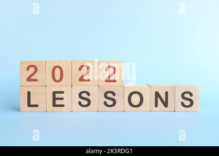 Jahr 2022 Life Lessons and Learnings Konzept. Holzblöcke auf blauem Hintergrund. Stockfoto