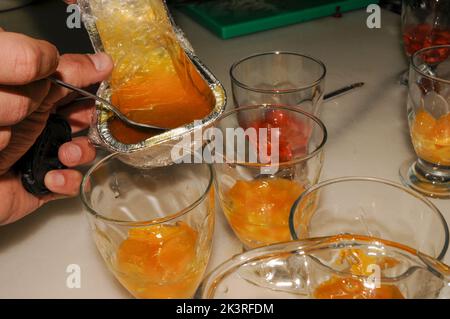 Zubereitung von Joghurt und Fruchtmousse in Glasbechern Stockfoto