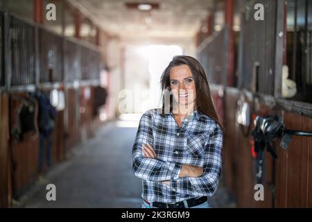 Der Besitzer des Stalls steht und schaut auf die Kamera Stockfoto