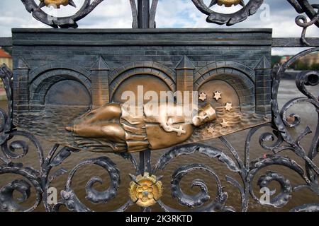 Eine Detailansicht des eisernen geschmiedeten Gitters mit dem Relief des Heiligen Johannes von Nepomuk auf der Karlsbrücke in Prag, Tschechische Republik. Stockfoto