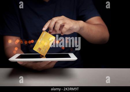 Mann hält Tablet und zeigt Kreditkarte, konzentriert sich auf Kreditkarte Quick Money Option Ideen Stockfoto