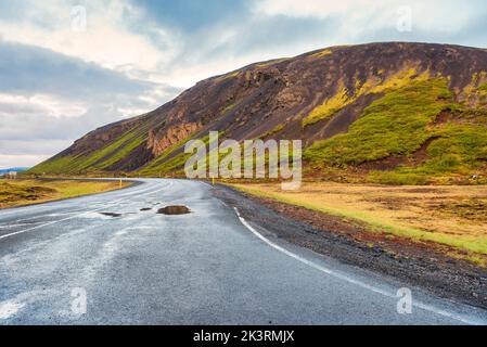 Mitten in Einer weiten offenen leeren Straße, umgeben von Bergen in Island Stockfoto