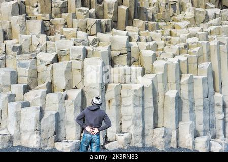 Mann auf dem Rücken, der auf natürliche Basaltsäulen blickt Stockfoto