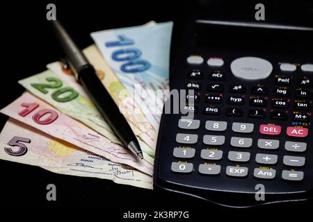 Die türkischen Lira-Banknoten und ein Rechner zur Berechnung der Rechnungen und Steuern Stockfoto