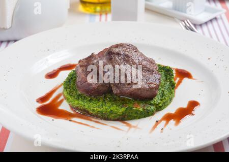 Das leckere Rindersteak auf einem Spinatbett in einem Restaurant Stockfoto