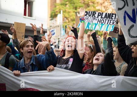 Jubelnde Teilnehmer*innen hinter Banner 'Klimagerechtigkeit jetzt!'. Am 23.9.2022 sammeln sich in München bis zu 10,000 Menschen, um gemeinsam mit Fridays for future auf dem globalen Klimabereich für Klimagerechtigkeit, den Ausbau der dezentralen erneuerbaren Energien, kostengünstigen ÖPNV und für ein 100 Mrd. Euro Sondervermögen für gerechte Klimaschutzmaßnahmen und Krisenprävention zu demontieren. Das Motto des Großstreiks war wieder People Not Profit. -- jubelnde Teilnehmer hinter dem Banner "Climate Justice Now! Am 23. September 2022 versammelten sich bis zu 10.000 Personen in München Stockfoto