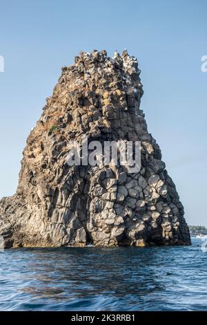 Die Faraglioni oder Isole dei Ciclopi (Zyklopen-Inseln), eine Gruppe vulkanischer Basaltmeeres, stapeln sich vor der Küste von Aci Trezza, Sizilien, Italien Stockfoto