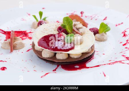 Leckere millefeuille mit drei Arten von Schokolade, pürierten Himbeeren und einem Weinbeutel Stockfoto