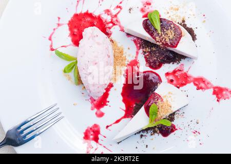 Leckerer Lavendelkäsekuchen mit Erdbeer- und Hibiskuseis. Draufsicht Stockfoto