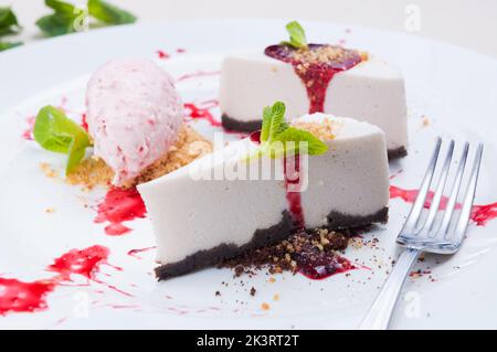 Leckerer Lavendelkäsekuchen mit Erdbeer- und Hibiskuseis Stockfoto