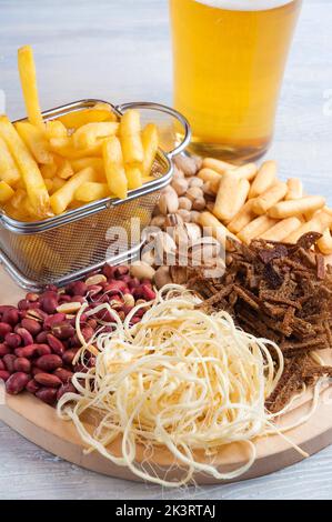 Leckere Biersnacks: Erdnüsse, Pistazien, Croutons, Käse, Pommes frites Stockfoto
