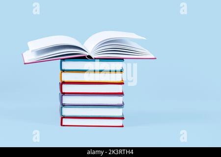 Stapel Bücher auf hellblauem Hintergrund. Vorderansicht, Platz für Text oder Produkt kopieren. Bildung, zurück zur Schule Konzept Stockfoto