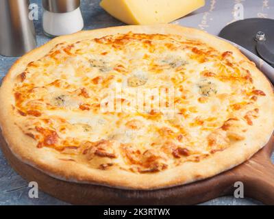 Leckere Pizza vier Käsesorten auf einem Holzbrett Stockfoto