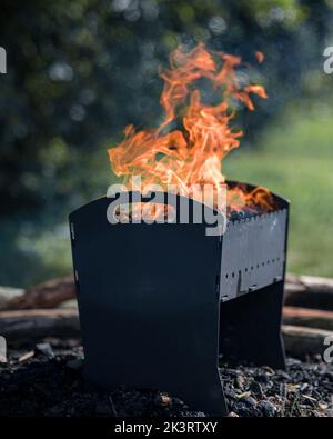 Brennendes Holz in einem Brazier. Vorbereitung auf ein Picknick. Der Baum brennt und raucht auf dem Grill Stockfoto