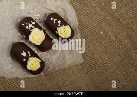 Tortenkartoffel. Dekoriert mit Buttercreme. Auf Leinenhintergrund. Nahaufnahme. Stockfoto