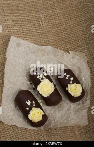 Tortenkartoffel. Dekoriert mit Buttercreme. Auf Leinenhintergrund. Nahaufnahme. Stockfoto