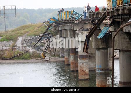 REGION CHARKIW, UKRAINE - 27. SEPTEMBER 2022 - die Menschen stehen auf der Brücke über das Petschenihy-Reservoir, das von den ukrainischen Streitkräften zerstört wurde Stockfoto
