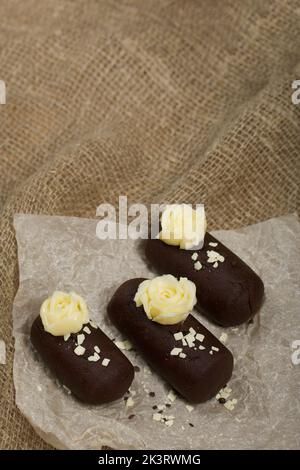 Tortenkartoffel. Dekoriert mit Buttercreme. Auf Leinenhintergrund. Nahaufnahme. Stockfoto