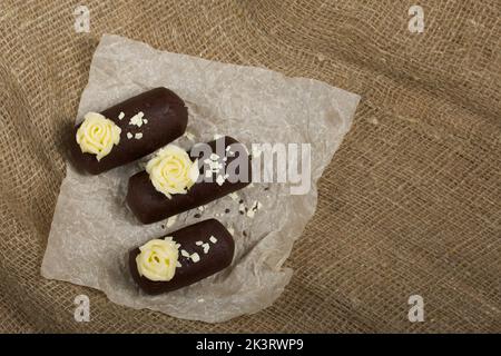 Tortenkartoffel. Dekoriert mit Buttercreme. Auf Leinenhintergrund. Nahaufnahme. Stockfoto