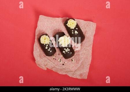 Tortenkartoffel. Dekoriert mit Buttercreme. Auf einem rosa Hintergrund. Nahaufnahme. Stockfoto